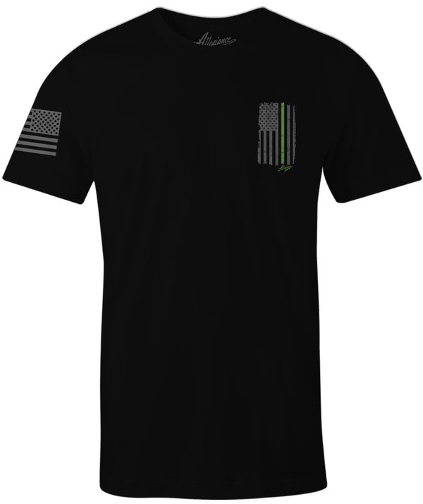 Black Allegiance Back the Green Tee featuring a small distressed black-and-gray American flag with a green line and monochrome flag sleeve print.